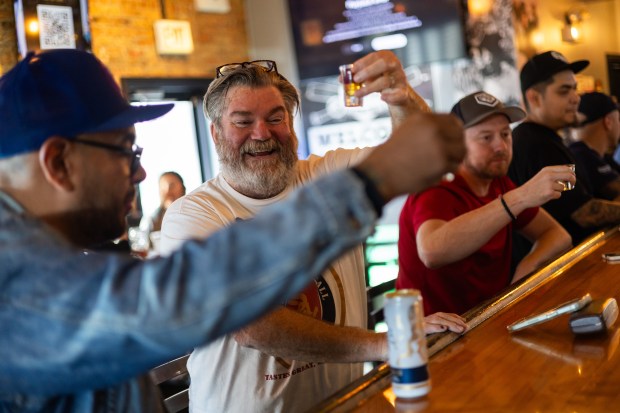 White Sox fan Tom O., center, takes a shot of malort with friends during a White Sox game against the Los Angeles Angels at BallPark Pub in Chicago on Sept. 26, 2024. Despite their record-tying 120 losses this season, the Sox won 7-0 against the Angels. (Tess Crowley/Chicago Tribune)