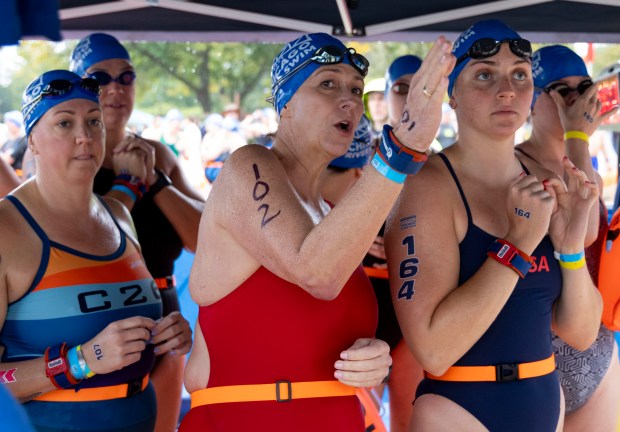 Mariel Hawley, center, of Mexico City, prepares to dive into the water at Ohio Street Beach on Sunday, Sept. 22, 2024. (Brian Cassella/Chicago Tribune)