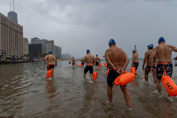 Swimmers wade into the water off Ohio Street Beach to begin the race on Sunday, Sept. 22, 2024. (Brian Cassella/Chicago Tribune)