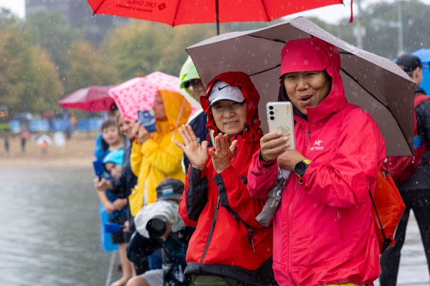 Spectators cheer in the rain as swimmers cross the finish line on Sunday, Sept. 22, 2024, as the inaugural Chicago River Swim is held in Lake Michigan. (Brian Cassella/Chicago Tribune)