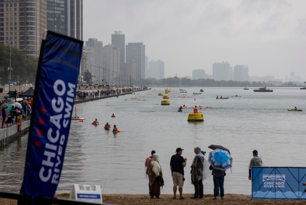 Spectators watch swimmers compete in the water off Ohio Street Beach on Sunday, Sept. 22, 2024. (Brian Cassella/Chicago Tribune)