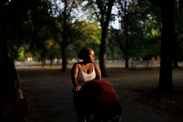 Frederica Confident, 26, from Jacmel, Haiti, poses for a portrait with her 3-month-old daughter Ivy Layanah Michel in Ronan Park near her home on Sept. 19, 2024, in Chicago. Confident left Jacmel because she couldn't work, there was no electricity and food was expensive, she said. (Armando L. Sanchez/Chicago Tribune)