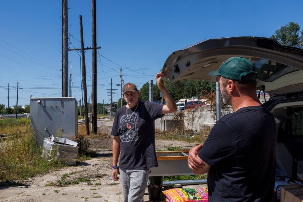 Matt Rowlee, outreach specialist, talks with Luke Tomsha, founder and director of the Perfectly Flawed Foundation, near a van before Rowlee distributes drug tests, harm reduction, and overdose prevention supplies to residents in the area on Sept. 4, 2024, in La Salle, Illinois. (Armando L. Sanchez/Chicago Tribune)