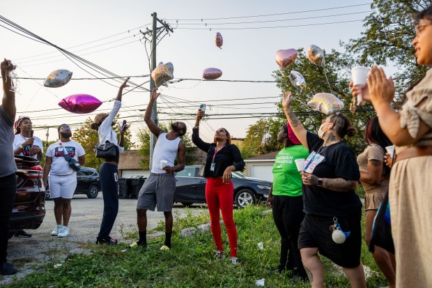 People release balloons during a LGBTQ+ organization TaskForce candlelit vigil on Sept. 11, 2024, honoring Red, a transgender woman who was shot and killed early Sunday morning. (Tess Crowley/Chicago Tribune)