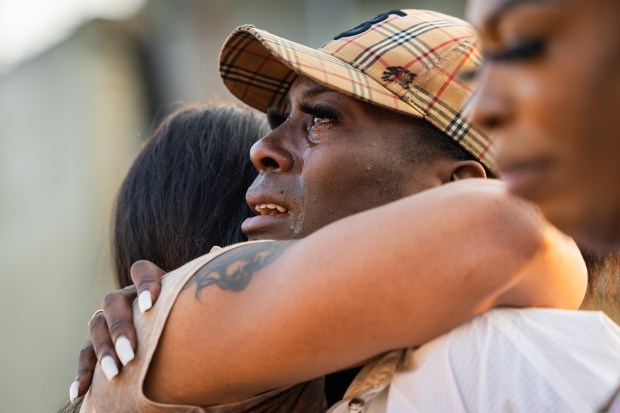 Michelle Lee embraces a friend during a LGBTQ+ organization TaskForce candlelit vigil honoring Red, a transgender woman who was shot and killed early Sunday in the West Garfield Park neighborhood of Chicago, Sept. 11, 2024. (Tess Crowley/Chicago Tribune)