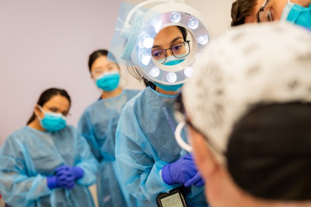 Fourth year UIC College of Dentistry student Komalpreet Kaur treats patient Russell Plambeck as fellow students watch at UIC College of Dentistry's Inclusive Care Clinic in Chicago on Aug. 28, 2024. (Tess Crowley/Chicago Tribune)