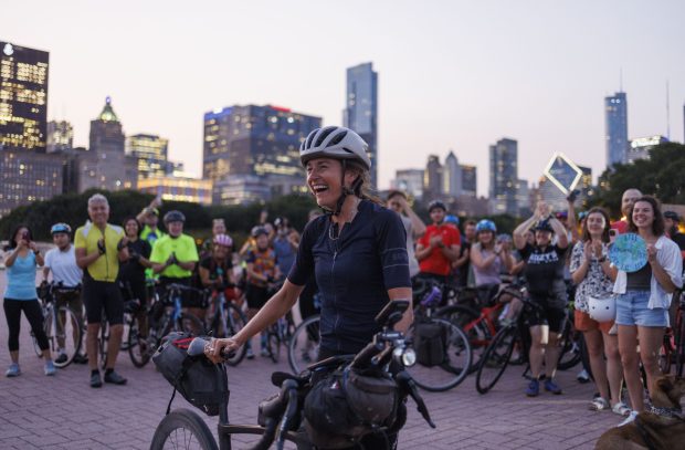 Lael Wilcox celebrates with supporters after completing her attempt to beat the Guinness world record for fastest women's circumnavigation of the globe on a bike, Sept. 11, 2024, in Chicago. (Armando L. Sanchez/Chicago Tribune)