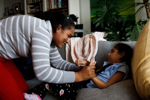 Yamile Perez holds her daughter Keinymar Avila's hands after undergoing virtual individualized education plan testing at a friends home on Nov. 4, 2023, in Chicago. (Armando L. Sanchez/Chicago Tribune)