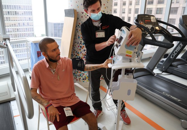 José Gómez, left, receives physical therapy from Charles Pocius at the Shirley Ryan AbilityLab in Chicago on Aug. 28, 2024. Gómez worked at a granite and marble company and was diagnosed with the lung disease silicosis. He recently received a lung transplant. (Terrence Antonio James/Chicago Tribune)