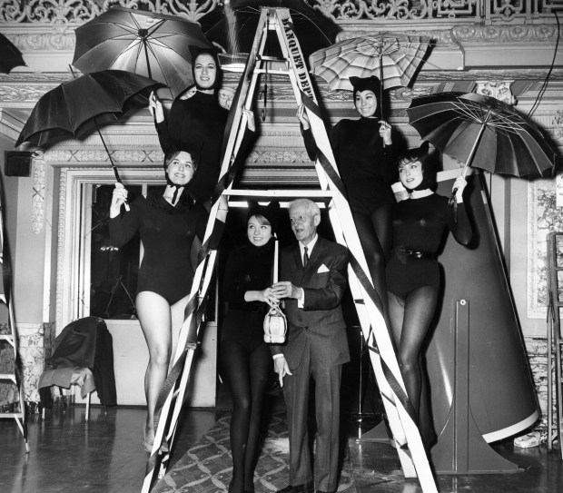 Bernadine Stevens, Judy Kurtz, Patty Allen, Tani Sawa and Connie Jean are with Nathaniel Leverone, founder of the Anti-Superstition Society, as he enters the Gold Room under a ladder at the Pick Congress Hotel on Dec. 13, 1963, in Chicago. (Leonard Bartholomew/Chicago Tribune)