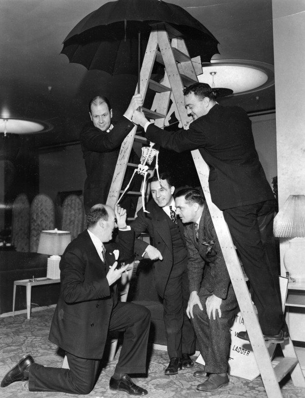 Judge Robert Dunne, Judge Rudolph DeSort and Joe Triner are under a ladder while Atty. Robert Cantwell and Eugene Dunne hold an umbrella above on Friday the 13th in 1940. The group was at the 13th anniversary dinner for the Anti-Superstition Society, held at the Merchants and Manufacturers Club. (Chicago Tribune historical photo)