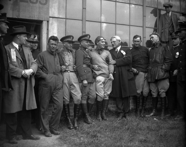 U.S. Army World Fliers are greeted by Chicago Mayor William Dever, with ribbon, when they landed in a small airfield just outside Chicago near suburban Maywood on Sept. 15, 1924. The flyers landed near Chicago on their final leg of their aerial circumnavigation of the globe. The flyers are, from left, Lt. John Harding Jr., Lt. Henry H. Ogden, Lt. Leslie P. Arnold, Lt. Leigh P. Wade, and (after Mayor Dever), Lt. Lowell H. Smith and Lt. Erik H. Nelson. (Chicago Tribune historical photo)