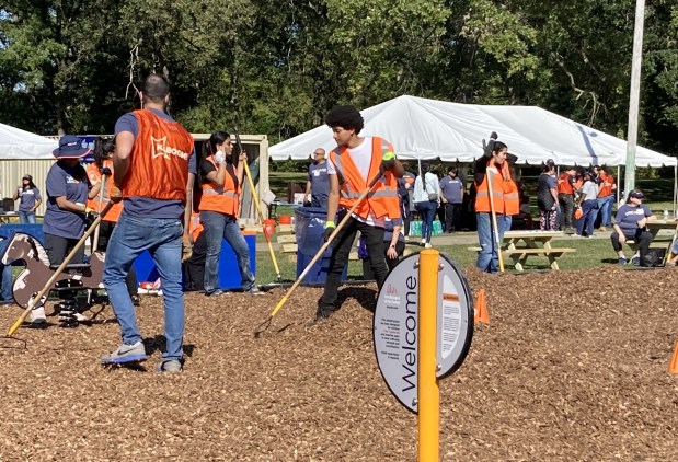 Volunteers spread mulch over part of the new playground at Twin City Park. (Steve Sadin/For the Lake County News-Sun)