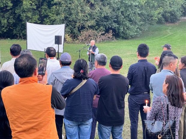 Norby Samphel leads a prayer for missing Tsering "Dolma" Wangyal, 82, of Skokie at a candlelight vigil in her honor at James Park on Sep. 9, 2024. (Richard Requena/Pioneer Press)