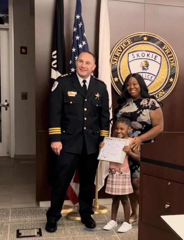 Zoey Reddick, 5-years-old and from Skokie, received the Citizen's Award from the Skokie Police Department for saving her mother's life. From left to right: Skokie Police Chief Jesse Barnes, Zoey Reddick, Jessica Reddick. (Skokie Police Department)