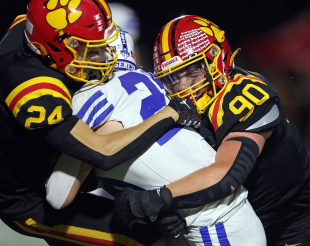 Batavia's Micah Johnson (24) and Gavin Pecor (90) wrap up Geneva's Michael Rumoro (20) in the third quarter during a DuKane Conference game in Batavia on Friday, Oct. 4, 2024.(H. Rick Bamman / The Beacon-News)