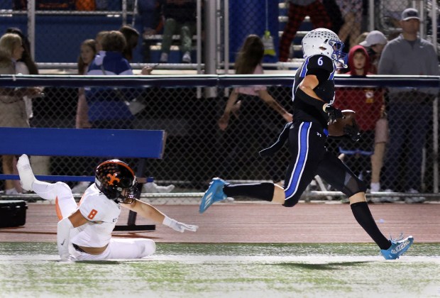 St. Charles North's Keaton Reinke, right, is knock out of bounds by St. Charles East's Dom Micaletti, left, during the game in St. Charles on Friday, Oct. 4, 2024. (James C. Svehla / Beacon News)