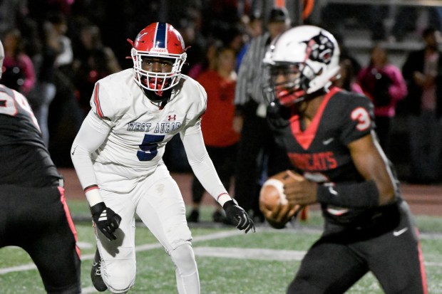 West Aurora's Temilade Dada (5) keeps his eye on East Aurora quarterback CJ Young in Aurora on Friday, Oct. 18, 2024. (Mark Black / for the Beacon-News)