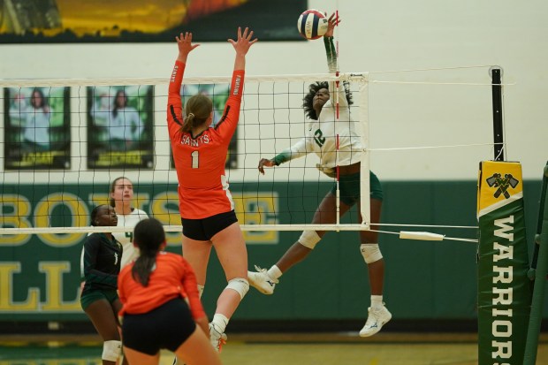 Waubonsie Valley's Naomi Dowd (12) goes up for a kill attempt against St. Charles East's Scarlett Dickerson (1) during a volleyball match at Waubonsie Valley High School on Wednesday, Oct 2, 2024. (Sean King / for The Beacon-News)