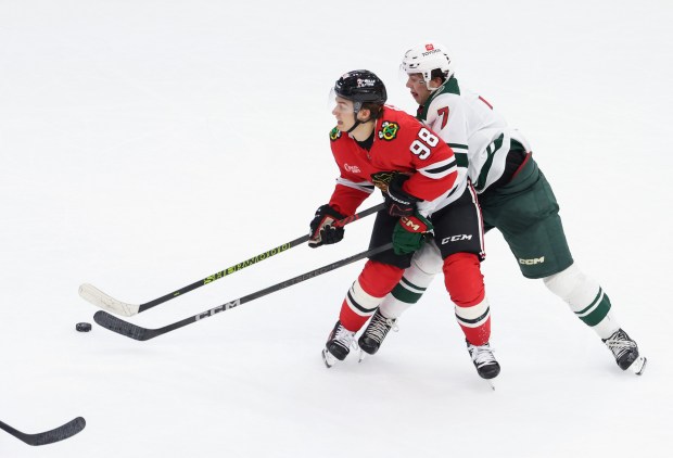 Blackhawks center Connor Bedard (98) and Wild defenseman Brock Faber (7) skate into each other in the second period of a preseason game at the United Center on Oct. 4, 2024, in Chicago. (John J. Kim/Chicago Tribune)