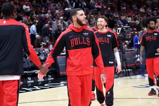 Bulls guard Lonzo Ball, center, greets teammates at the United Center in Chicago before the start of a game against the Timberwolves on Oct. 16, 2024. (Terrence Antonio James/Chicago Tribune)