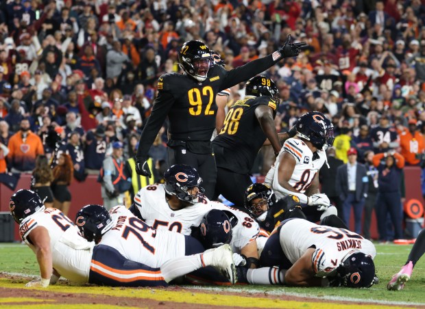 Commanders defensive end Dorance Armstrong gestures a turnover signal as Bears offensive linemen are piled on the ground after center Doug Kramer Jr. fumbles the ball at the goal line in the fourth quarter at Northwest Stadium on Oct. 27, 2024, in Landover, Maryland. (John J. Kim/Chicago Tribune)