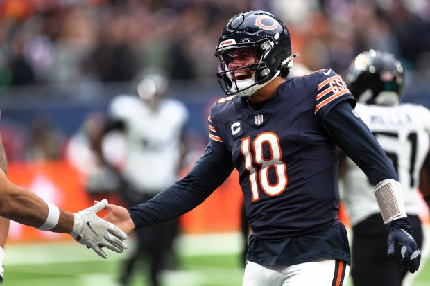 Bears quarterback Caleb Williams is congratulated after completing a pass to wide receiver DJ Moore to the goal line in the fourth quarter against the Jaguars at Tottenham Hotspur Stadium in London on Oct. 13, 2024. (Chris Sweda/Chicago Tribune)