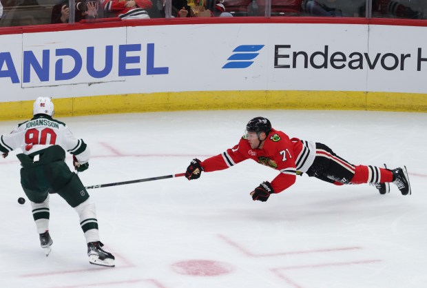 Blackhawks left wing Taylor Hall (71) dives for the puck as Wild center Marcus Johansson (90) chases in the second period of a preseason game at the United Center on Oct. 4, 2024, in Chicago. (John J. Kim/Chicago Tribune)