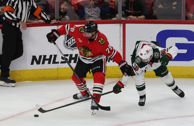 Blackhawks defenseman TJ Brodie (78) and Wild center Marcus Johansson (90) joust for the puck in the second period of a preseason game at the United Center on Oct. 4, 2024, in Chicago. (John J. Kim/Chicago Tribune)