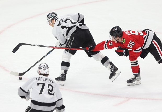 Blackhawks defenseman Kevin Korchinski (55) lunges after Kings left wing Trevor Moore (12) in the second period at the United Center on March 15, 2024, in Chicago. (John J. Kim/Chicago Tribune)