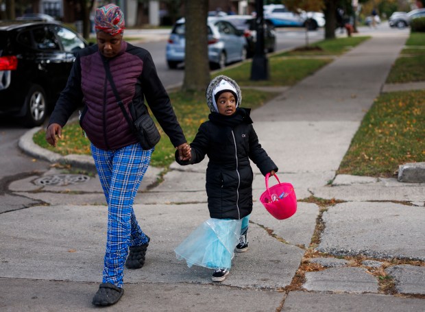 Lisa Johnson takes her 5-year-old daughter Heaven Randall trick-or-treating in the Englewood neighborhood, Oct. 31, 2024, in Chicago. (Armando L. Sanchez/Chicago Tribune)