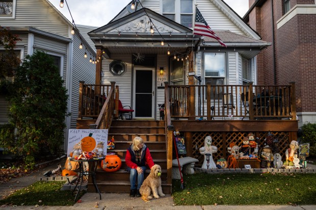 Kathy Minneci and dog Sadie wait for trick-or-treaters on Halloween in the Roscoe Village neighborhood of Chicago. (Tess Crowley/Chicago Tribune)