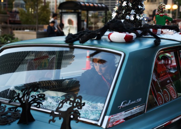 Zora Alleyne of a group called Big Elves sits in a vintage car before the Arts in the Dark Halloween Parade on Oct. 19, 2024. (John J. Kim/Chicago Tribune)