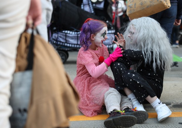 Lorelei Wilson, 7, left, and Julia Paskiewicz, 11, work on their scary faces before marching in the Arts in the Dark Halloween Parade Oct. 19, 2024. (John J. Kim/Chicago Tribune)