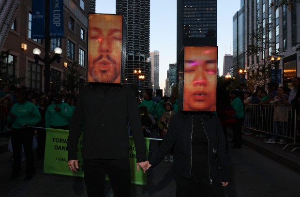 Architects Robert Becker, left, and Sharon Xu, of Studio Becker Xu, are dressed as the Crown Fountain as they march in the Arts in the Dark Halloween Parade. (John J. Kim/Chicago Tribune)