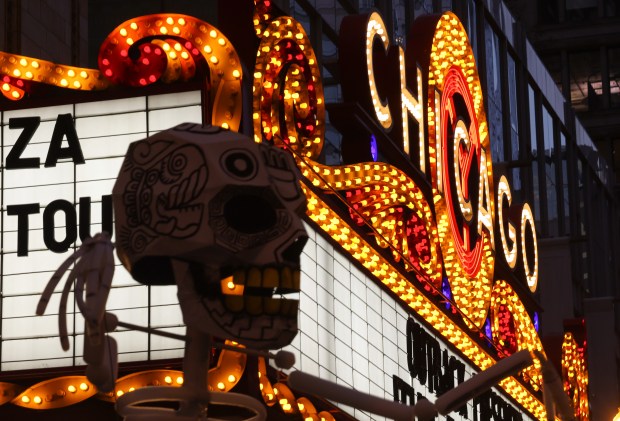 A Day of the Dead skeleton is positioned near the Chicago Theatre marquee during the Arts in the Dark Halloween Parade on State Street. (John J. Kim/Chicago Tribune)