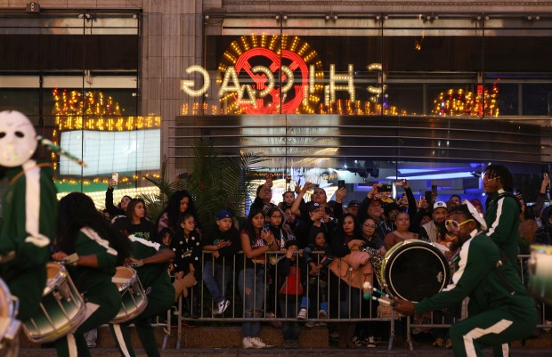 The Chicago Theatre marquee is reflected on windows as people watch the Arts in the Dark Halloween Parade on State Street Saturday, Oct. 19, 2024, in Chicago. (John J. Kim/Chicago Tribune)