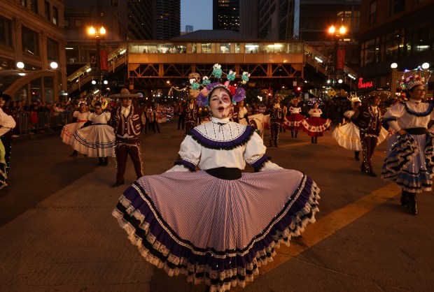 A member of the Back of the Yards Ballet Folklórico begins marching in the Arts in the Dark Halloween Parade on Oct. 19, 2024. (John J. Kim/Chicago Tribune)