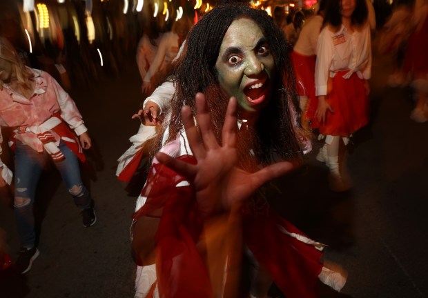 A parade participant makes scary gestures during the Arts in the Dark Halloween Parade. (John J. Kim/Chicago Tribune)