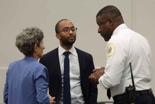 Chicago Police Supt. Larry Snelling, right, speaks with police board president Kyle Cooper, center, and vice president Paula Wolff before a meeting on Feb. 22, 2024. (John J. Kim/Chicago Tribune)