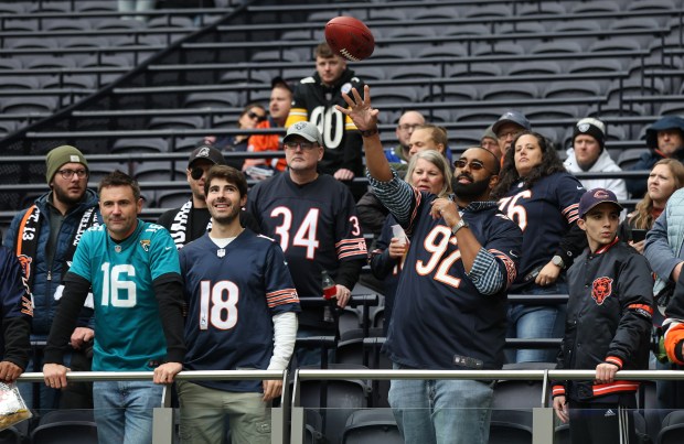 A Chicago Bears fan plays catch with a player during warmups for a game between the Bears and the Jacksonville Jaguars at Tottenham Hotspur Stadium in London on Oct. 13, 2024. (Chris Sweda/Chicago Tribune)