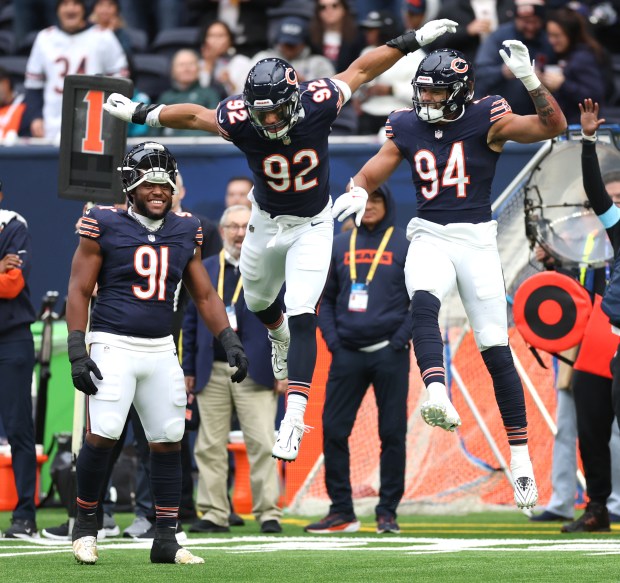 Bears defensive ends Daniel Hardy (92) and Austin Booker (94) celebrate after they stopped the Jaguars on a kickoff return in the second quarter at Tottenham Hotspur Stadium in London on Oct. 13, 2024. (Chris Sweda/Chicago Tribune)