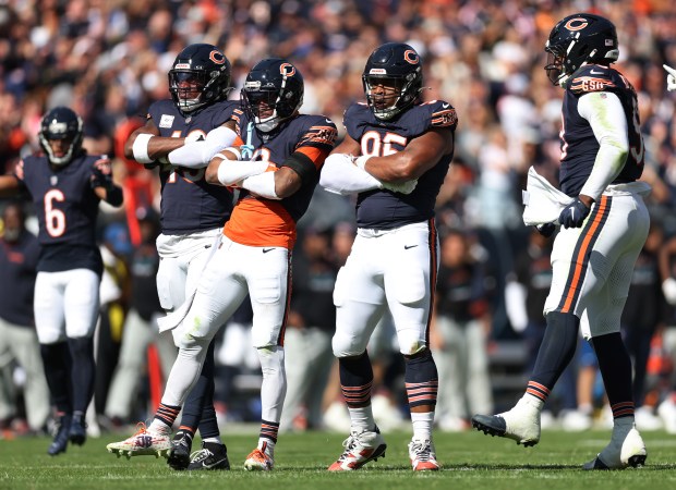 L to R: Chicago Bears players Tremaine Edmunds, Jaquan Brisker, and DeMarcus Walker, react after a big defensive play in the first quarter of a game against the Carolina Panthers at Soldier Field in Chicago on Oct. 6, 2024. (Chris Sweda/Chicago Tribune)