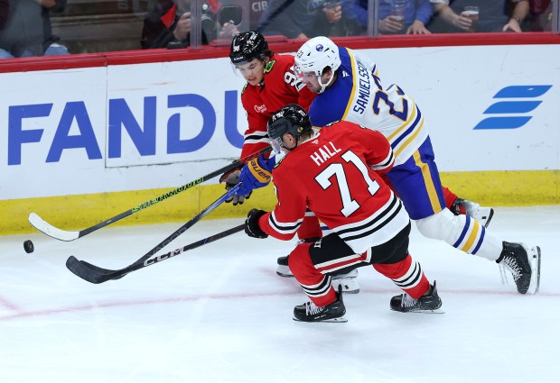 Chicago Blackhawks center Connor Bedard (98) and left wing Taylor Hall (71) battle Buffalo Sabres defenseman Mattias Samuelsson (23) in the second period of a game at the United Center in Chicago on Oct. 19, 2024. (Chris Sweda/Chicago Tribune)