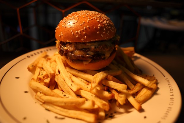 Queenie's double white cheddar burger will be offered at Queenie's Supper Club during the 2024-2025 season at the United Center. (Eileen T. Meslar/Chicago Tribune)