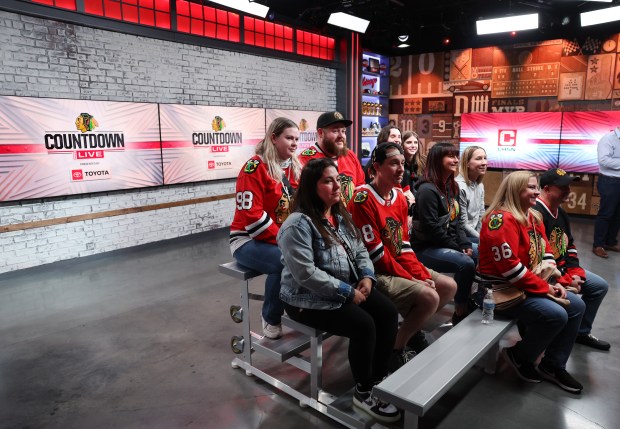 Blackhawks fans watch the Blackhawks Countdown Live pregame show from the back of the studio before the home opener at the United Center on Oct. 17, 2024. (Chris Sweda/Chicago Tribune)