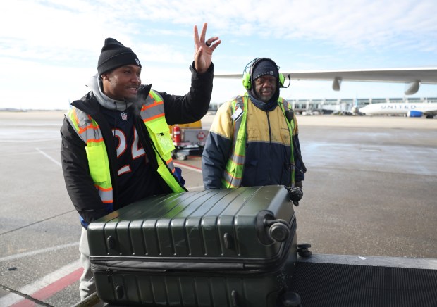 Chicago Bears running back Khalil Herbert loads a bag onto a United Airlines flight at O'Hare International Airport on Tuesday, Dec. 19, 2023. Three Bears players handled some airline duties as part of a promotional appearance. (Trent Sprague/Chicago Tribune)