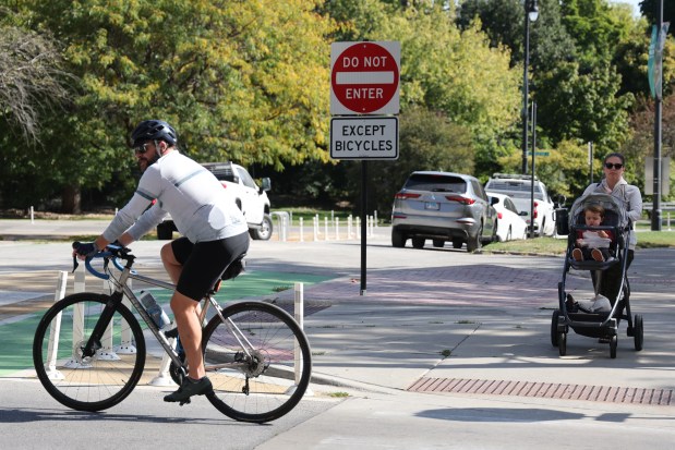 A bicyclist rides north along Lincoln Park West, past Dickens Drive, in Chicago's Lincoln Park neighborhood, Oct. 9, 2024. (Antonio Perez/Chicago Tribune)