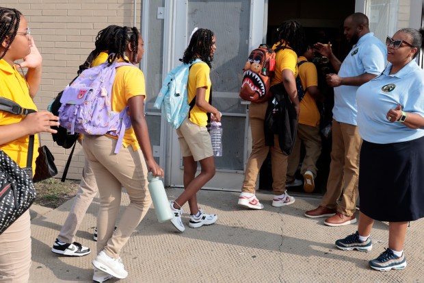 Staff greet students arriving for their first day back to school at Chalmers Elementary Specialty School in Chicago, Aug. 26, 2024. (Antonio Perez/Chicago Tribune)