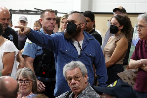 A man is removed from a public meeting held to discuss the homeless encampments at nearby Gompers Park on Sept. 30, 2024. He claimed the gathered officials and activists did not care about homeless people. (Terrence Antonio James/Chicago Tribune)